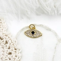 Macro view of 18K gold plated Evil Eye pendant with blue crystal and micro pavé accents - Full Zirconia Eye