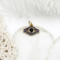 Detail of 18K gold evil eye charm with blue micro-pave crystals and black center stone - Blue Zirconia Hollow Eye
