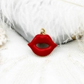 Detailed close-up of a red enamel lip-shaped pendant with a polished 18k gold-plated metal ring - Lip