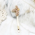 Dettagli macro del fermaglio a fiocco placcato oro 18K con zirconi incastonati a mano - Design Fiore a Tre Petali