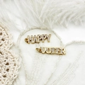 Vue macro des pendentifs HAPPY et VOTER plaqués or 18 carats sur de la dentelle - Lettre VOTER