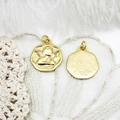 Macro detail of 18K gold plated angel charms with relief design on lace background - Angel
