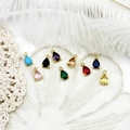 Detailed view of nine colorful teardrop gemstone pendants in golden prong settings - Teardrop Pendant