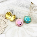 Close-up of heart-shaped sunburst locket necklaces with pink and cyan enamel detailing - Pink Sun Pattern (M0255)