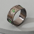 Detail view of black metal ring with green animal paw print design and drop glaze finish - Green Paw Prints Wide Band Style (J148 Black Nickel) / Black Nickel (J148)