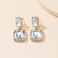 Elegant gold drop earrings with emerald cut clear crystals on a minimalist background - Clear