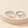 Detail of silver Scorpio zodiac and heart engraved ring set on a beige display - US 7 / Scorpio
