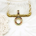 Vue détaillée d'un pendentif en zircon arc-en-ciel plaqué or 18k sur des plumes blanches - S1 / Lettre O