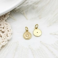 Macro view of gold sunburst charm with central zircon and smooth mirror finish back - Compass
