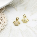 Macro shot of gold crown pendants with micro-pave zircons and textured details for DIY jewelry - Crown