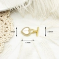Macro detail of 18K gold clover heart clasp with white shell inlay and zircon accents - White Shell Heart
