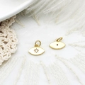 Macro detail of gold eye-shaped charm pendants showing front and back craftsmanship - Eye