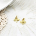 Macro detail of golden bee charms with zircon inlay on white lace and feather backdrop - Dragonfly