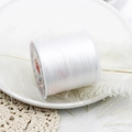 Macro detail of transparent elastic jewelry string on a white spool for DIY bead weaving - White 60m/Roll