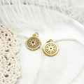 Macro detail of gold compass star pendant with zircon pave and engraved direction letters - Micro-pave Compass