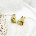 Macro detail of golden fist charms with red stones on a white decorative background - Red Hand Gesture