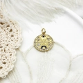 Macro shot of gold pendant with micro-pave charms on white feather and lace background - Small Round Disc