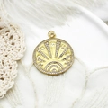 Macro shot of gold boho sunburst pendant with white zircon inlays and celestial symbols - Sun Round