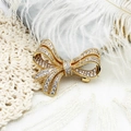 Elegant gold bow brooch with micro-pave crystals on white feather and lace background - Bowknot 35*29.2mm