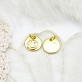 Macro view of 18K gold-plated smiley face pendants on lace and feather background - 3D Glossy Smiley Face