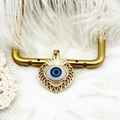 Close-up of gold 18K plated heart pendant with evil eye inlay and sunburst design - Hollow Heart Eye