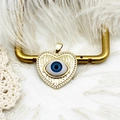 Détail du pendentif cœur en or 18 carats avec motif œil protecteur et ailes ciselées - Cœur Mauvais Œil