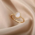 Vue macro d'une bague vintage dorée avec pierre opale ovale sur fond en satin plissé - Ouvert Réglable / Œil de Chat Artificiel Blanc Ovale (JZ2881G-2)