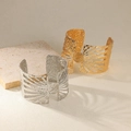 Detail of wide metal cuff bracelets with hammered texture and sunburst cut-out patterns - Radial Hollow Disc Style (B1725) / Gold