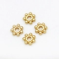 Close-up of four 18K gold-plated snowflake spacer beads for DIY jewelry making - 5mm / Snowflake Spacer