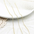 Detalle de cadenas de bolas chapadas en oro de 18K en bandeja blanca con plumas - Cadena de Cuentas (1.5)