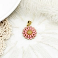 Makro-Detail eines 18K vergoldeten Gänseblümchen-Anhängers mit rosa Emaille auf Spitze - S1 / Rosa Gänseblümchen