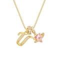 Detalle de collar dorado con letra U de circonita y colgante de planeta corazón rosa - Letra U