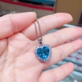 Nahaufnahme des herzförmigen blauen Kristallanhängers mit Zirkonia-Halo und Silberkette - Aquamarin Versilbert Mit Titanstahlkette