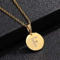 Detalle macro de collar chapado en oro con colgante de letra F y cristales sobre fondo negro - Letra F