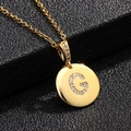 Detalle del collar con letra G dorada y micropavé de circonitas sobre soporte de cuero - Letra G