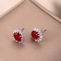 Detalle de pendientes de rubí con halo de circonitas en montura de metal plateado - Rojo