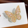 Gedetailleerde close-up van een gouden vlinderring met roze en witte zirkonia steentjes - Goud Roze Zirkoon