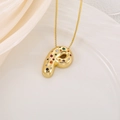 Détail d'un pendentif lettre P doré avec des pierres de zircon colorées sur du tissu en soie - Lettre P