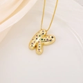 Vue détaillée du pendentif lettre K doré avec zircons multicolores sur soie blanche - Lettre K