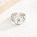 Nahaufnahme eines Silberrings mit Zirkonia-Buchstabe F und Ziegeltextur-Oberfläche - Buchstabe F Stil