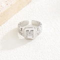 Makroaufnahme eines silbernen Rings mit Zirkonia-Buchstaben M auf einem Gliederkettenband - Buchstabe M Stil