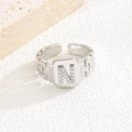 Detailansicht eines silbernen geometrischen Rings mit Zirkonia-Buchstabe N auf Platte - Buchstabe N Stil