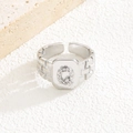 Nahaufnahme von silbernem Ring mit quadratischer Textur und Zirkonia-Buchstabe Q - Buchstabe Q Stil