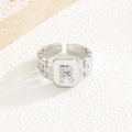Detailaufnahme des silbernen Rings mit Zirkon-Buchstabe R und strukturierter Schiene - Buchstabe R Stil