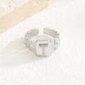Makroaufnahme des silbernen T-Rings mit Zirkonia und strukturierter Ringschiene - Buchstabe T Stil