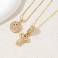 Close-up of gold plated letter Y pendants with clear cubic zirconia stones and chains - Letter Y
