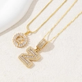 Close-up of two gold-plated necklaces featuring zircon-studded letter N pendants - Letter Z