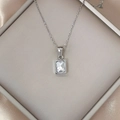 Luxurious stainless steel necklace featuring a square zircon pendant on silk background - White