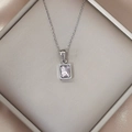Macro shot of silver necklace with rectangular lavender zircon pendant on silk - Peach