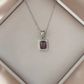 Detailed view of silver necklace featuring a rectangle red zircon pendant in a luxury box - Red